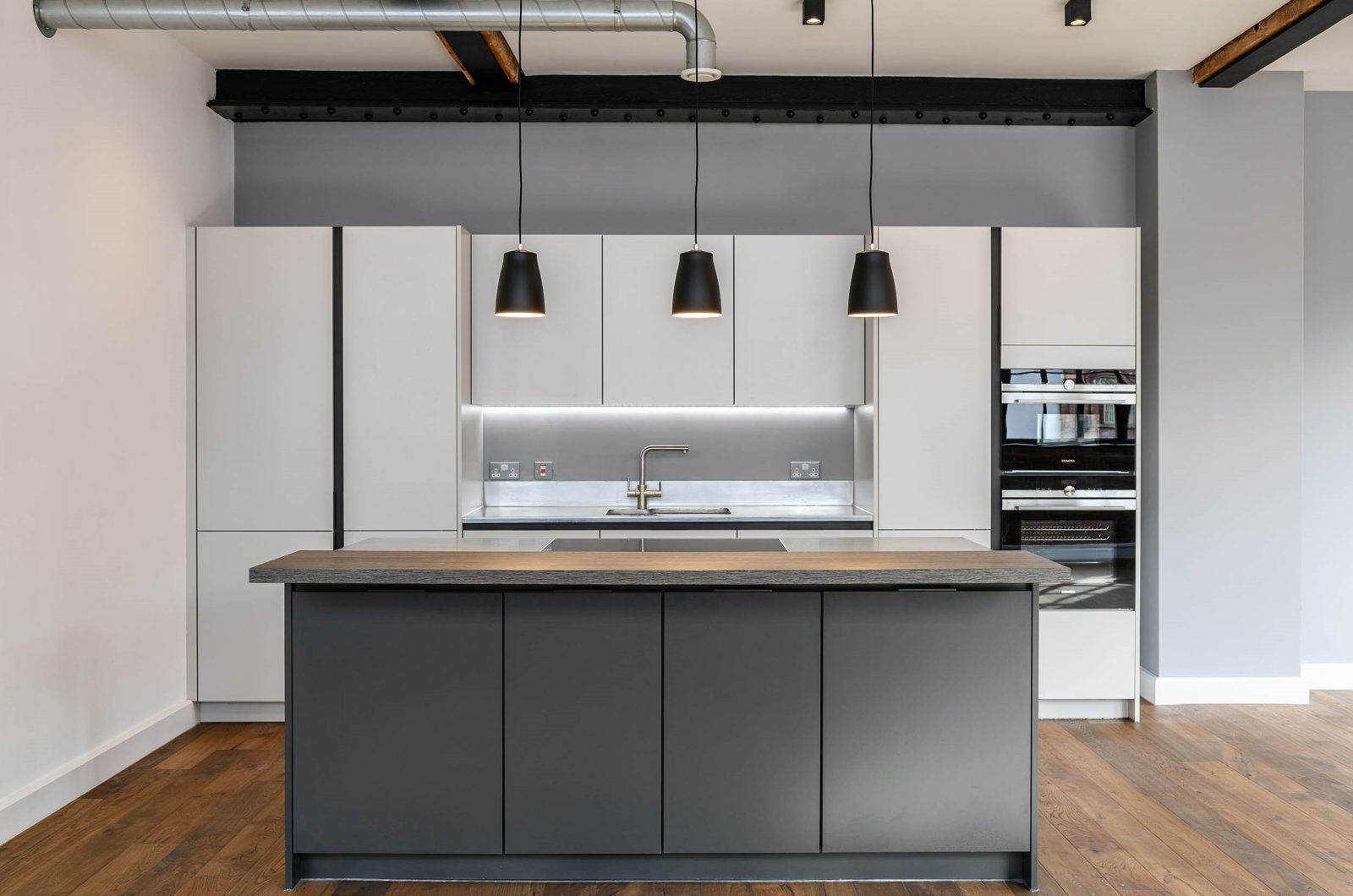 LIV Projekt modern black and grey kitchen with 3 black pendant lights in an industrial style room
