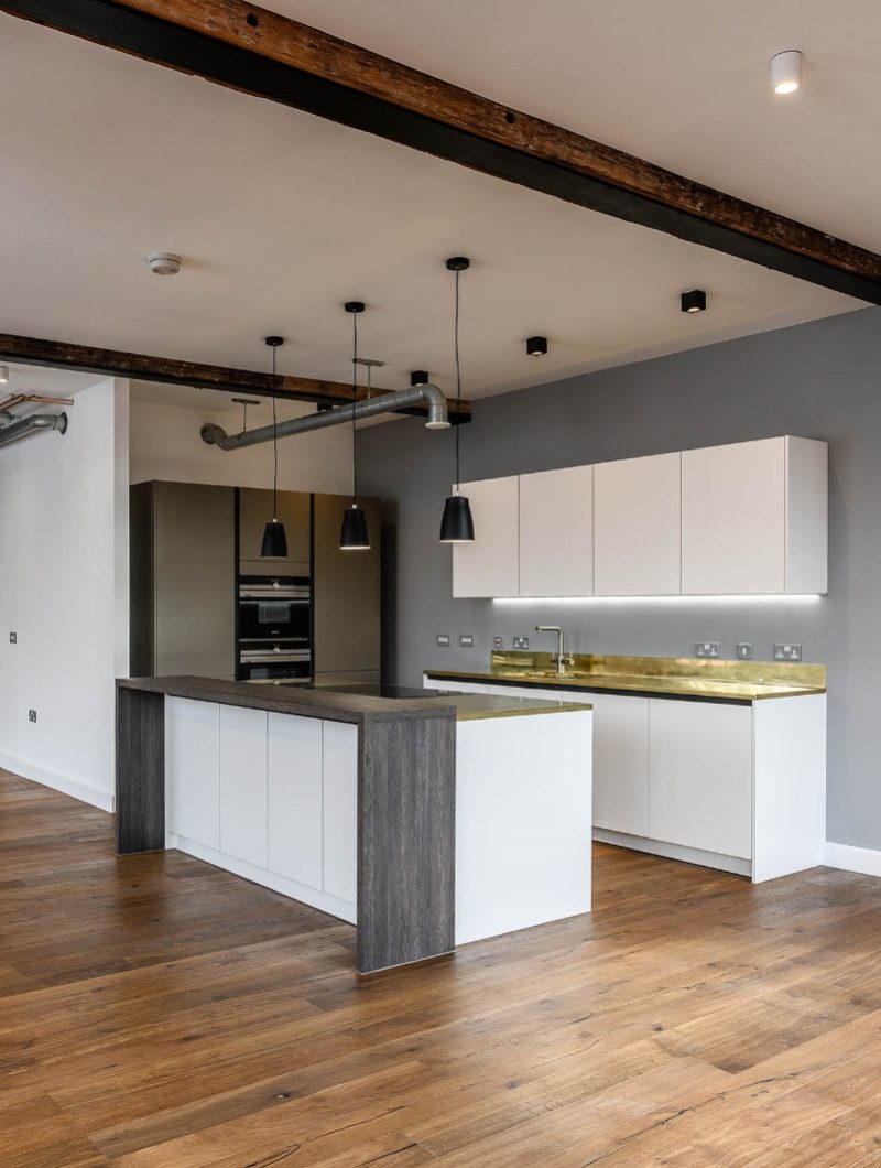 Live Projekt industrial apartment kitchen with modern white cabinets and gold worktop
