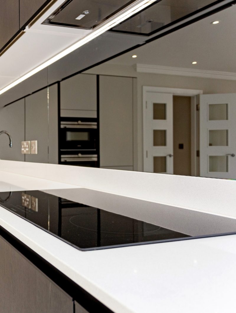 Tudor place project kitchen with white worktops and reflective backsplash