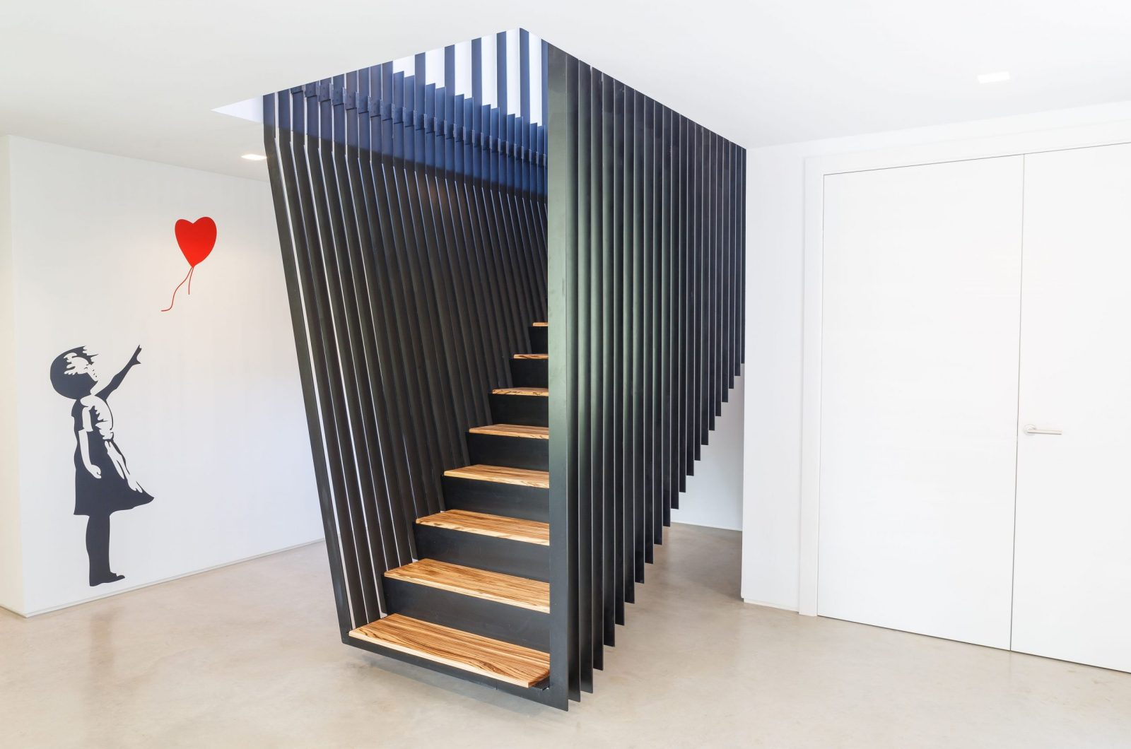 Studio Spicer project modular metal staircase with Banksy inspired mural on the wall